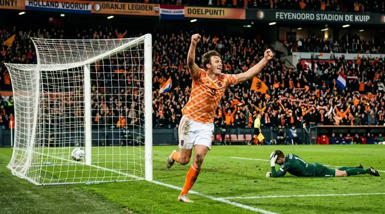 Voetbalactie in de Eredivisie met doelpuntenscorer en juichende supporters